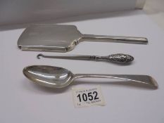 A hall marked silver backed hand mirror, a silver spoon and a silver handled button hook.