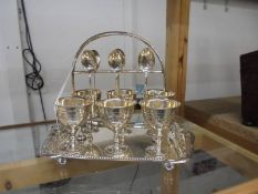 A good quality silver plate egg cup stand with six egg cups and spoons.