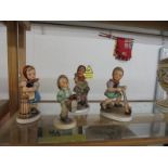 Three Friedel Bavaria girl figures and a Goebel boy figure.