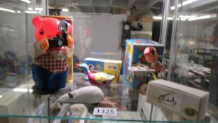 A tinplate battery operated bear with flash camera, clockwork ice cream vendor,swimming duck & mouse