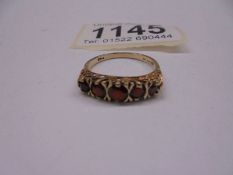 A ring set with five garnets in a graduated design, dated London 1981 in 9ct gold.