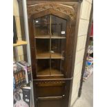 A dark oak glazed top corner cupboard