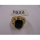 A yellow metal ring set black onyx, size R half. 68gms
