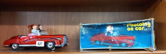 A boxed tin plate battery operated photoing on car, mint in working order, box tatty