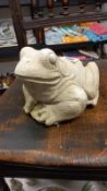 A concrete frog garden ornament