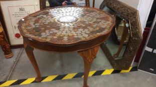 A coffee table with top filled with coins including centre coin, COLLECT ONLY