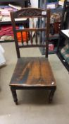 A 19th century oak hall chair with spindle & carved back