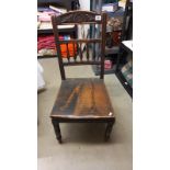 A 19th century oak hall chair with spindle & carved back