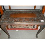 A dark oak coffee table with carved top under glass. COLLECT ONLY.