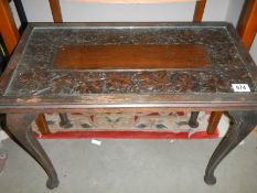 A dark oak coffee table with carved top under glass. COLLECT ONLY.