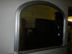 An arched top overmantel mirror in silver coloured frame, COLLECT ONLY.