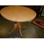 A solid pine circular table with centre pedestal. COLLECT ONLY.
