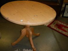 A solid pine circular table with centre pedestal. COLLECT ONLY.
