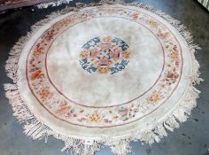 A beige coloured circular rug - 166cm diameter (including tassels) COLLECT ONLY