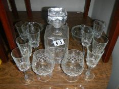 A glass decanter and a quantity of glasses.