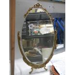 A oval gilt ormolu framed mirror on stand, COLLECT ONLY.