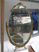 A oval gilt ormolu framed mirror on stand, COLLECT ONLY.