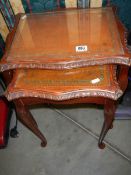 A nest of two tables with tooled leather tops under glass, COLLECT ONLY.