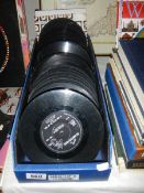 A box of 45 rpm vinyl records, no sleeves.