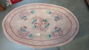An oval rug depicting dragons - 123cm x 76cm at widest points, COLLECT ONLY