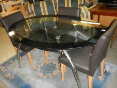 An oval glass top dining table and three chairs, COLLECT ONLY.