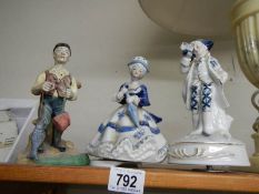 A figure of a fisherman and two blue and white figures.