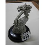 A metal dragon on a wooden base.