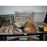 A shelf of assorted matchboxes, coins, fans etc.,