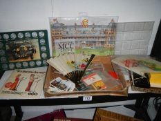 A shelf of assorted matchboxes, coins, fans etc.,