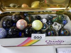 A tin box full of large & small glass marbles