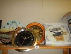 A shelf of assorted wall clocks.