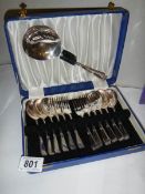 A cased set of dessert spoons and forks with serving spoon.