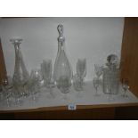 Three glass decanters and a quantity of drinking glasses.