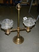 An old brass double candle lamp with glass shades.