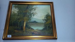 A gilt framed oil on canvas of wooded lake signed Samuel