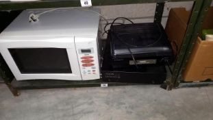 A Panasonic DMR-EZ49V VHS DVD Player and a Steepletone Record Player and a Sanyo Microwave.