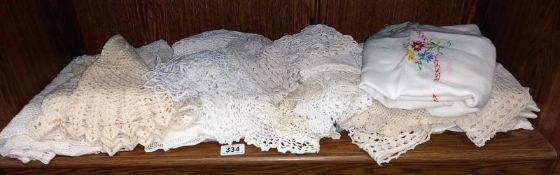 A shelf of linen doilies etc