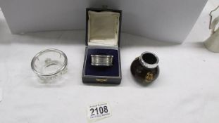 A cased silver napkin ring and two silver rimmed items.