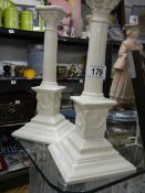 A pair of white ceramic candlesticks.