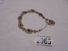 A 9ct gold bracelet set amethysts with safety chain and padlock, 15.1 grams total.
