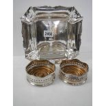 A pair of silver plate wine coasters and a silver plate dish.