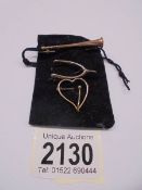 A 9ct rose gold stirrup brooch, A rose gold flute brooch and a 9ct heart brooch, 4.4 grams total.