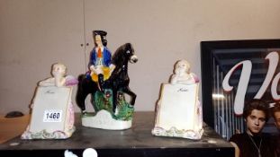 A pair of continental bisque angels menu holders and a Staffordshire figure of Dick Turpin on a