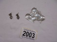 A pair of silver Macintosh earrings and a Mexican silver cat brooch.