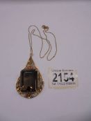 An 18ct gold pendant set large square cut stone (possibly smoky quartz) on a 750 gold chain.