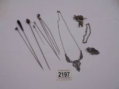 Eight hat pins, a silver marcasite necklace, a silver bracelet, a silver mother brooch