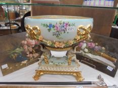 A large porcelain bowl supported by two cherubs. COLLECT ONLY