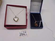 A silver and mother of pearl heart locket and an unmarked amber pendant.