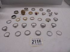 Approximately thirty yellow and white metal dress rings.