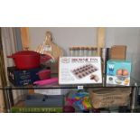 A quantity of 'new' kitchen items, includes casserole dish, baking trays, pizza slice, chopping